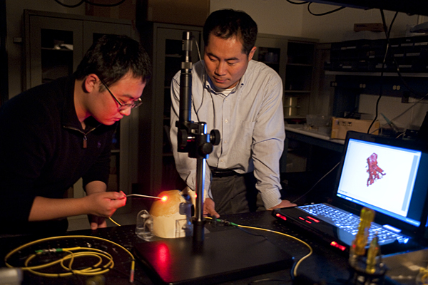 Jin U. Kang, standing, and doctoral student Kang Zhang work with a prototype of an optical tool for ‘virtual’ biopsies. Photo Courtesy: Will Kirk, HomewoodPhoto.jhu.edu