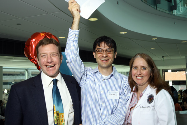 On Match Day, Paul Doherty, center, celebrates his acceptance as one of the four inaugural members of the Johns Hopkins Internal Medicine–Pediatrics Urban Health Residency Program. With him are Leonard Feldman, the program’s director, and Rosalyn Stewart, its associate director. Photo: Keith Weller